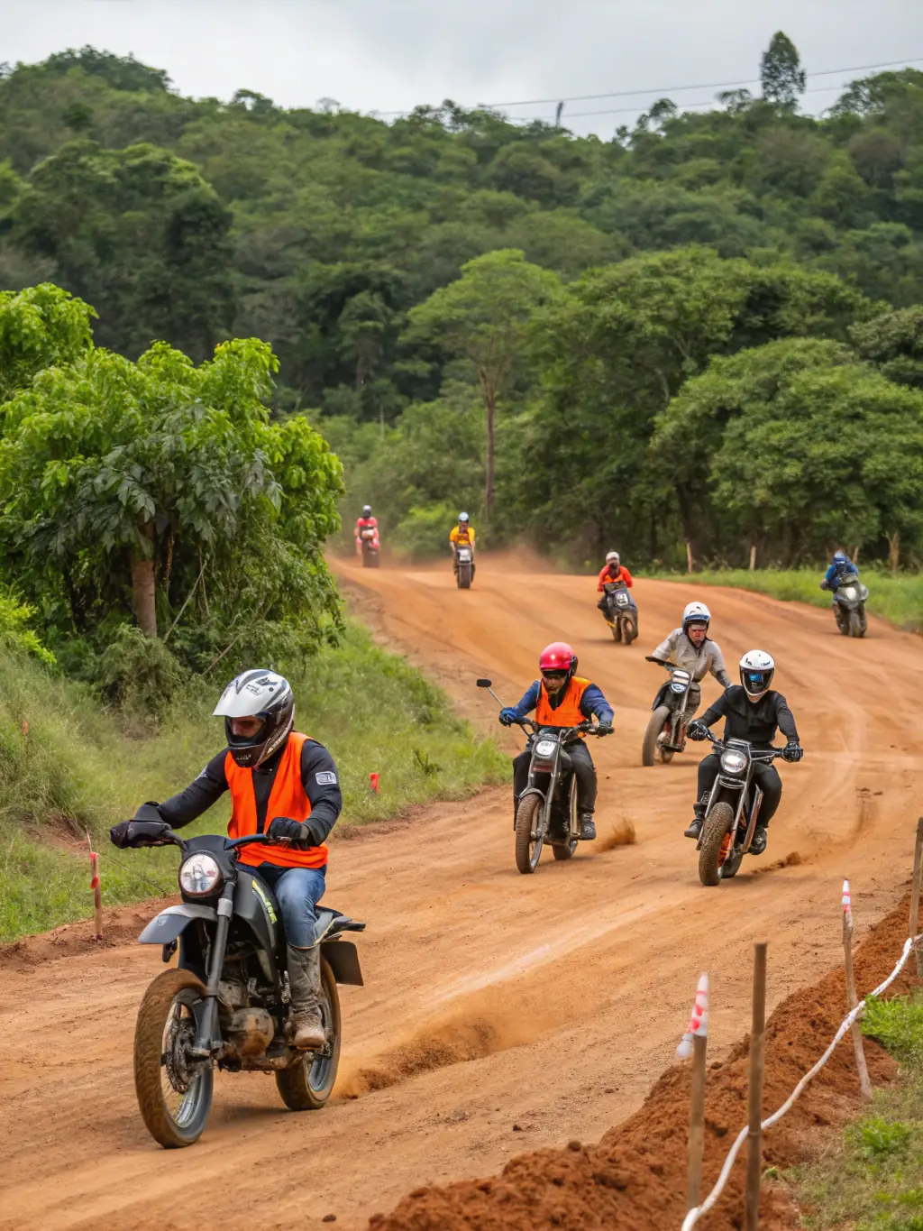 Action shot of TEAM NBK members participating in a motocross training session, focusing on technique and safety, set against a blurred background of the training grounds.